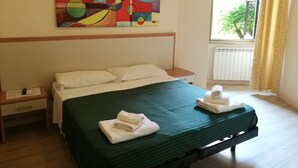A hotel room with a bed, a nightstand, a painting, and a window with curtains. - Palma Residence (Rome)