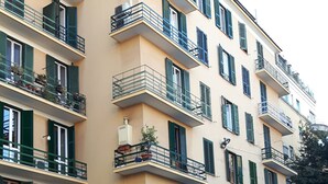 A multi-story building with balconies, a gated entrance, and parked vehicles. - Palma Residence (Rome)