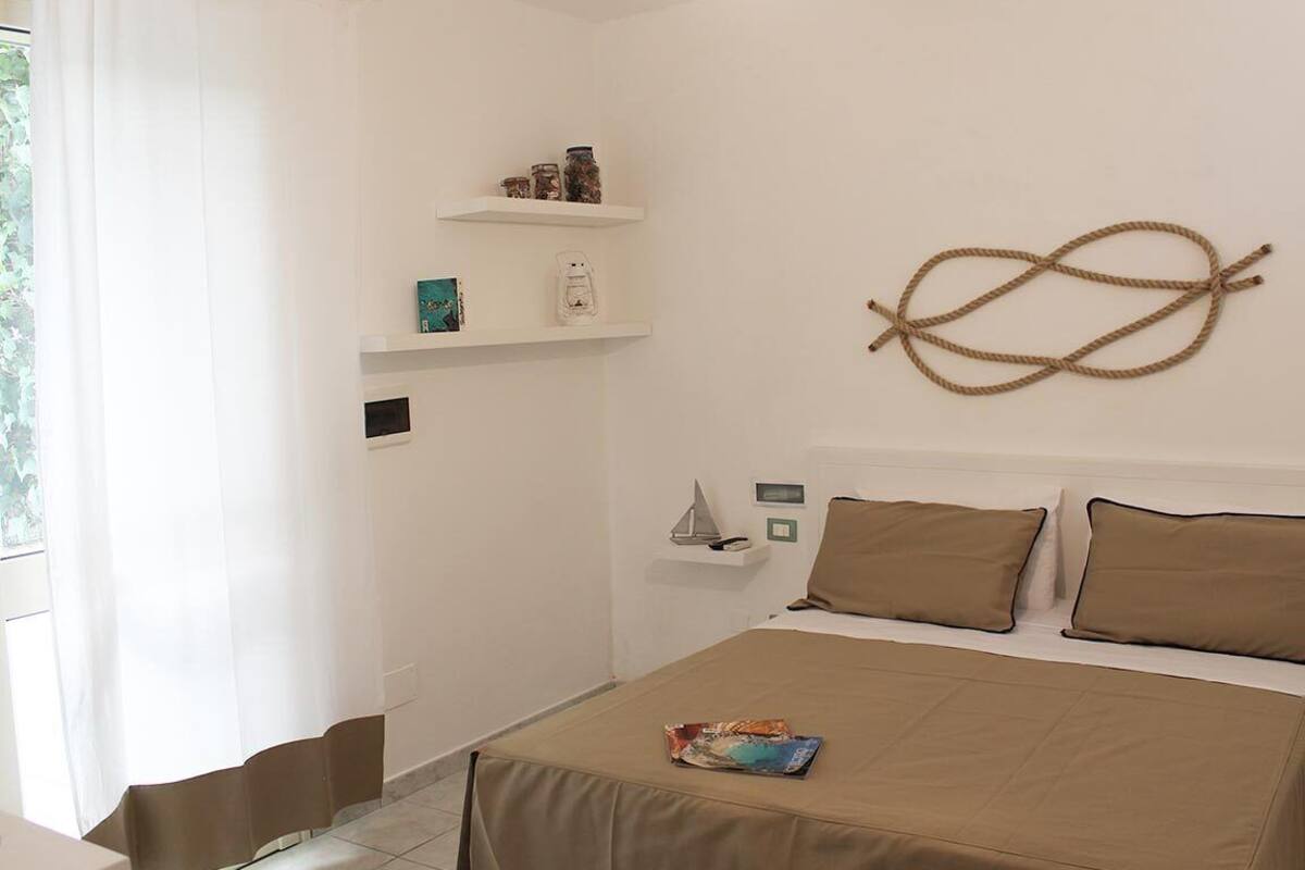 Une chambre à coucher avec un lit, une table de chevet, une étagère avec des bocaux et un élément décoratif mural.