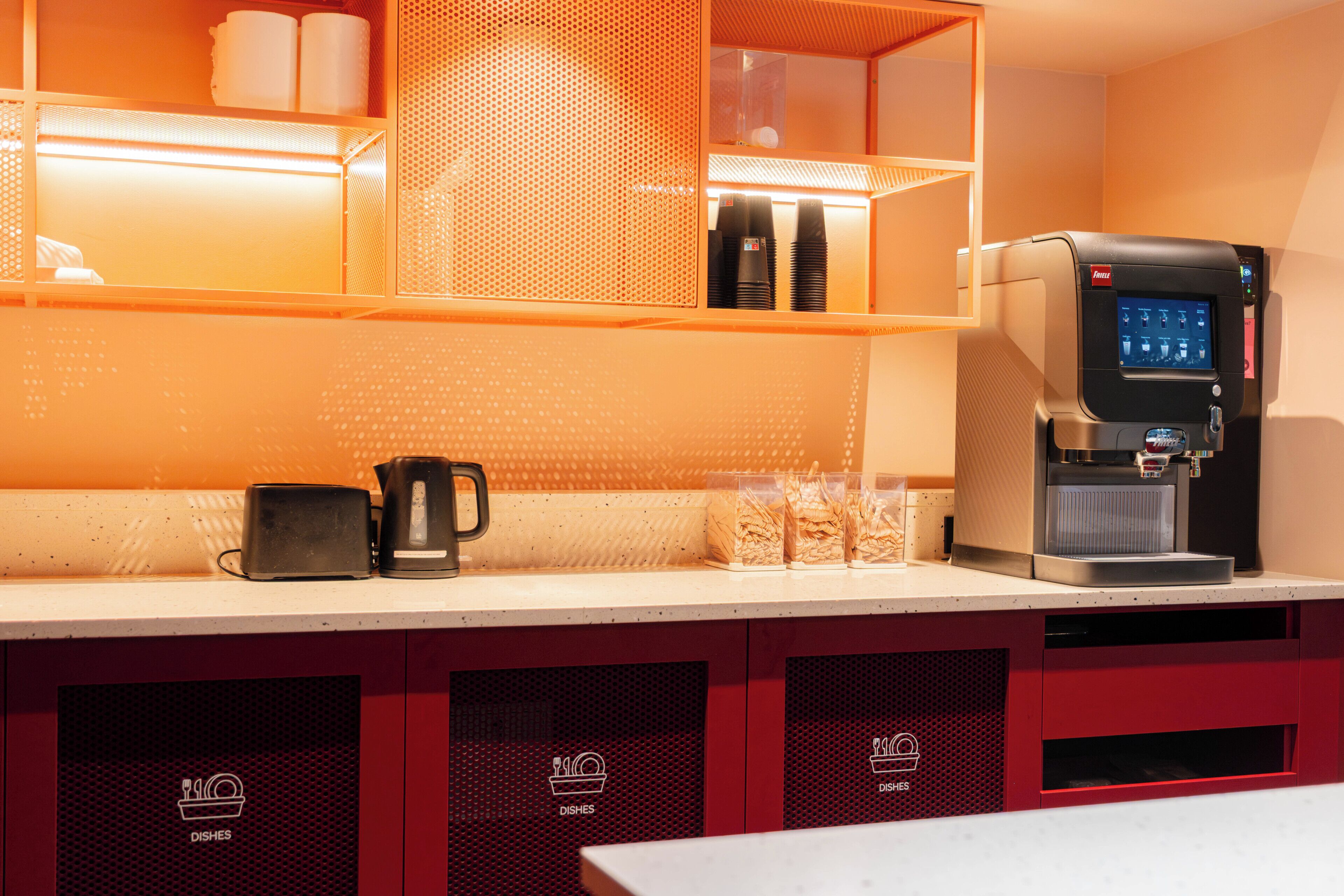 A kitchenette with a coffee machine, a toaster, and a microwave.