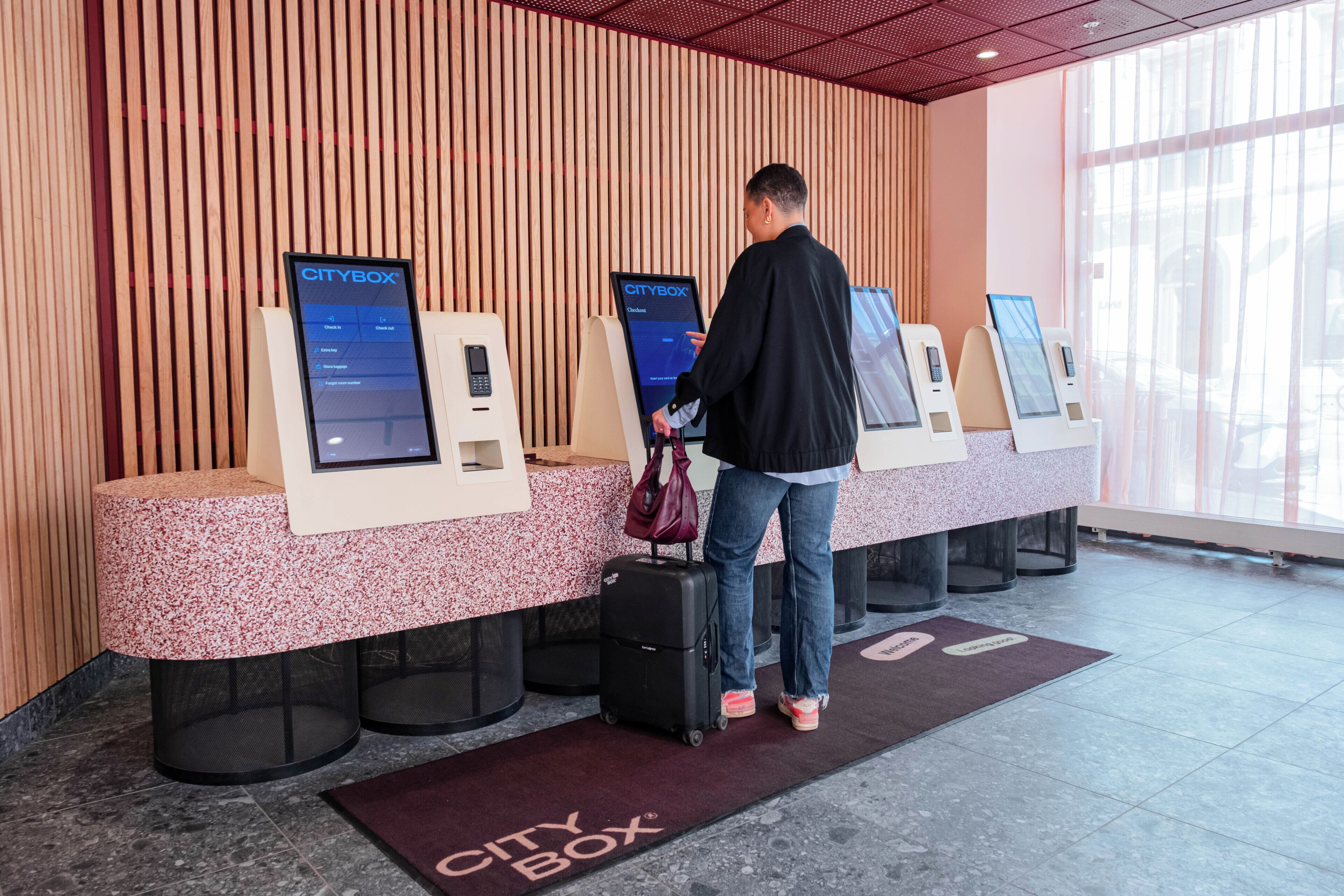 A check-in area with CityBox kiosks, a marble reception desk, and a marble floor.
