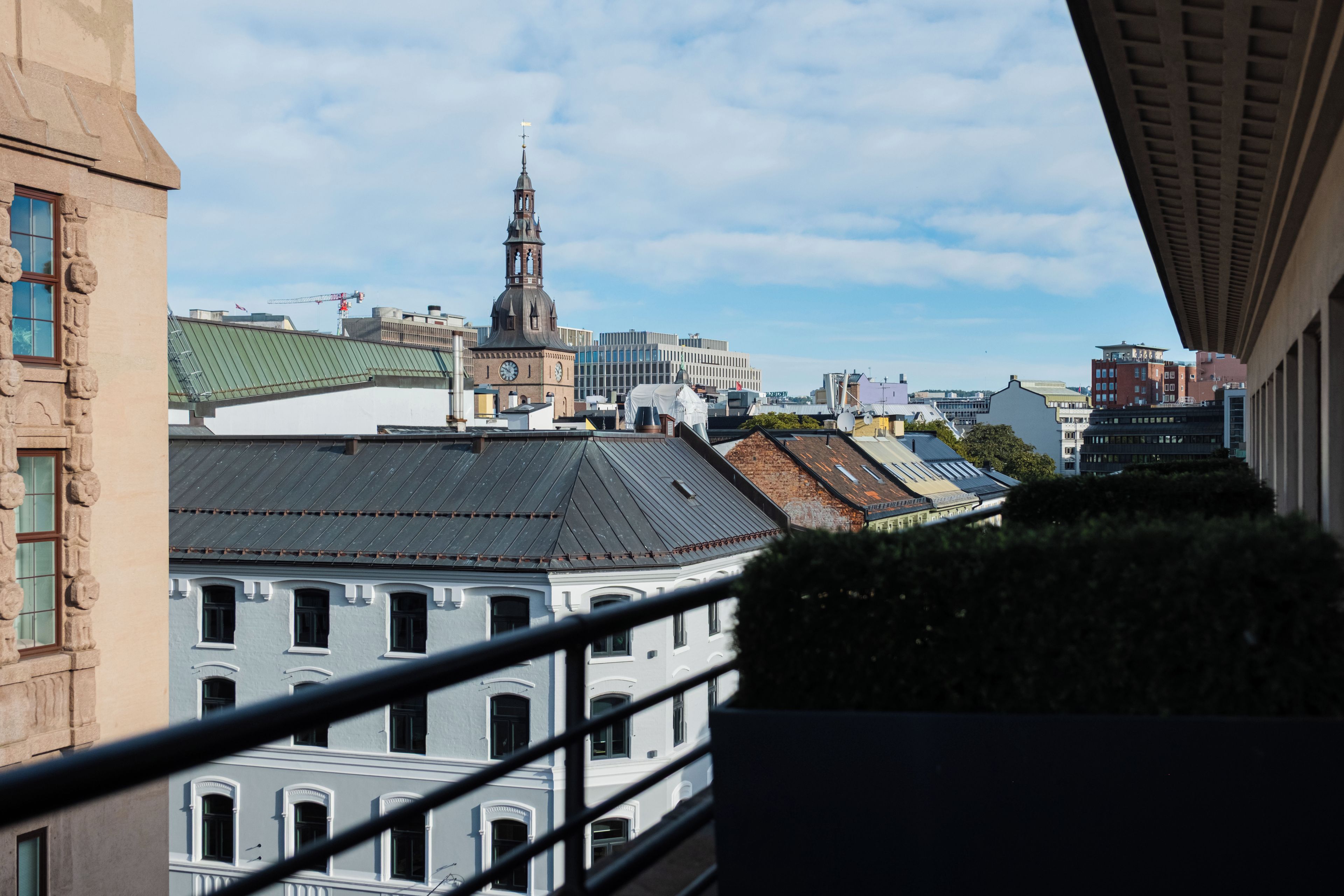 A cityscape with a prominent clock tower, modern buildings, and a mix of architectural styles.