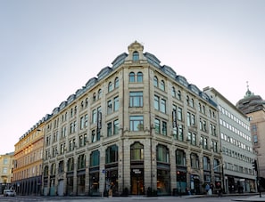 A historic building with multiple CityBox stores on the ground floor, featuring classic architecture with large windows and a prominent corner entrance. - Citybox Oslo (Oslo)