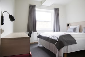 A hotel room with a bed, a desk, a chair, a window with curtains, and a skylight. - Citybox Oslo (Oslo)