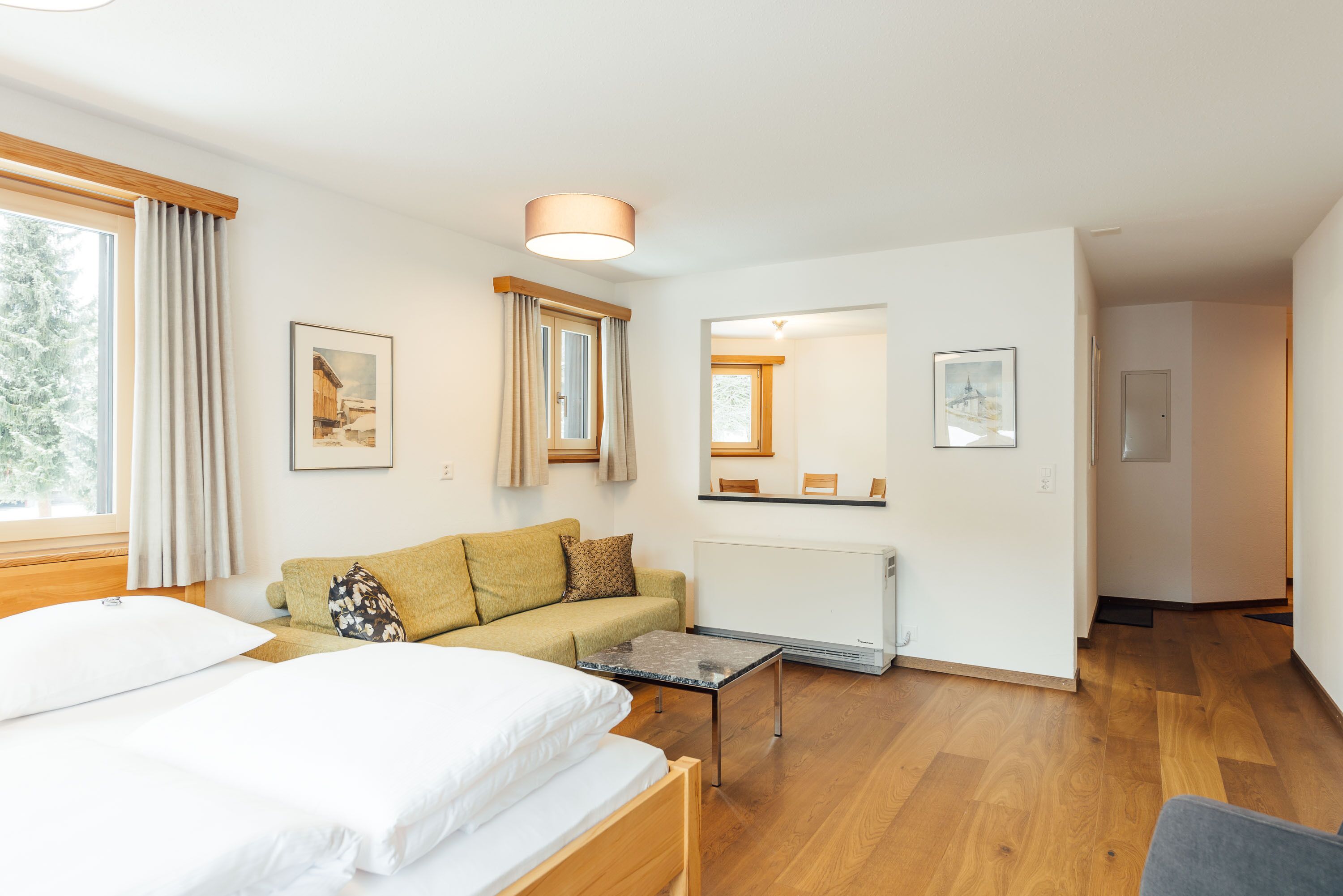 Ein modernes Hotelzimmer mit einem Bett, einer Couch, einem kleinen Tisch und einer Heizung.