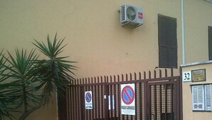 A gated entrance with a no parking sign and a no stopping sign, a potted plant, and a building number 32. - Guest House Masterintrastevere (Rome)