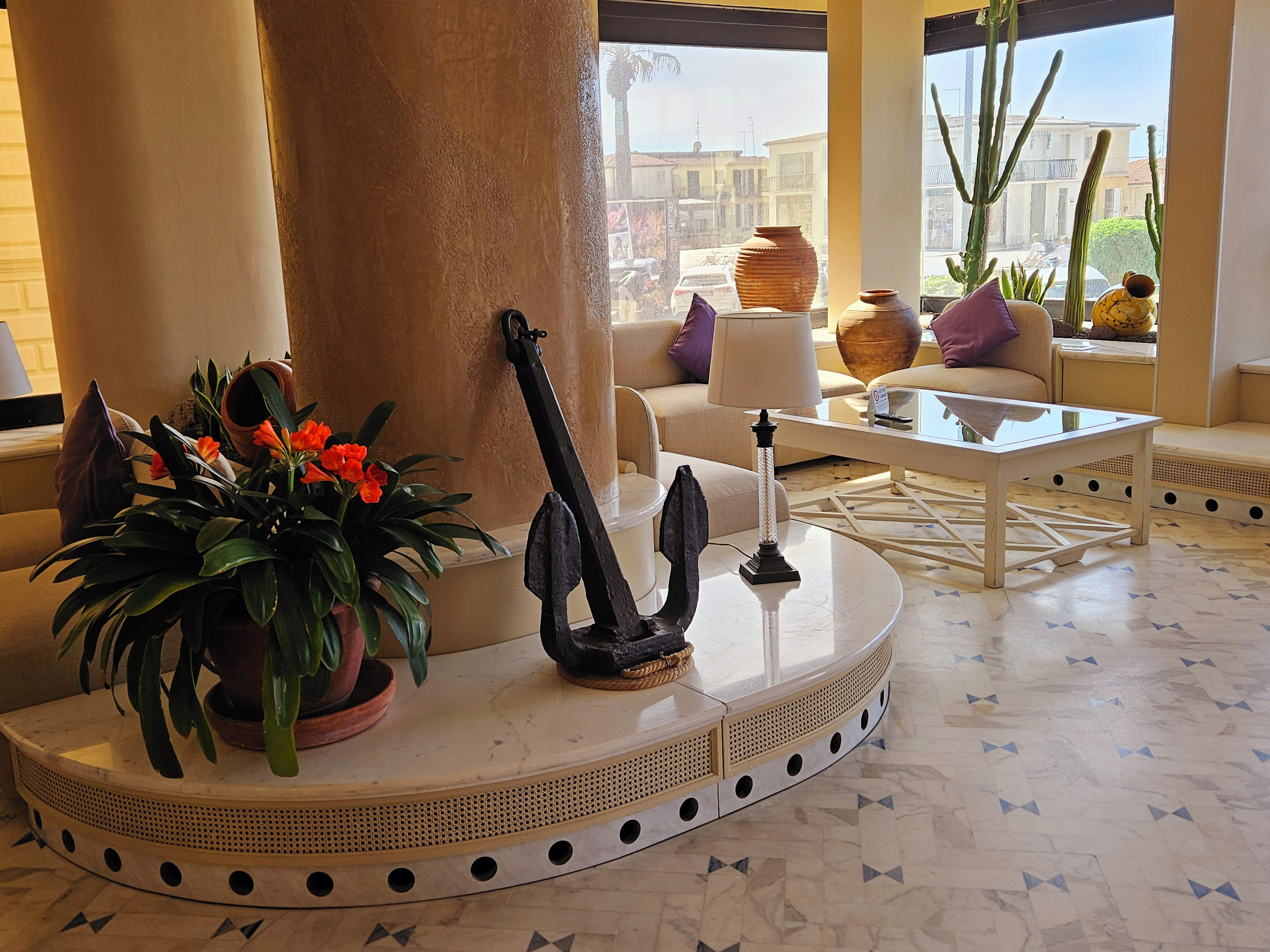 A well-lit room with a round table, a potted plant, and a decorative sculpture.