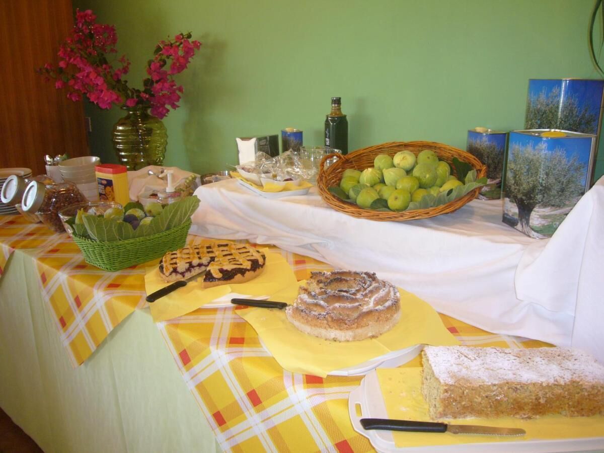 A table with various food items and a vase of flowers.