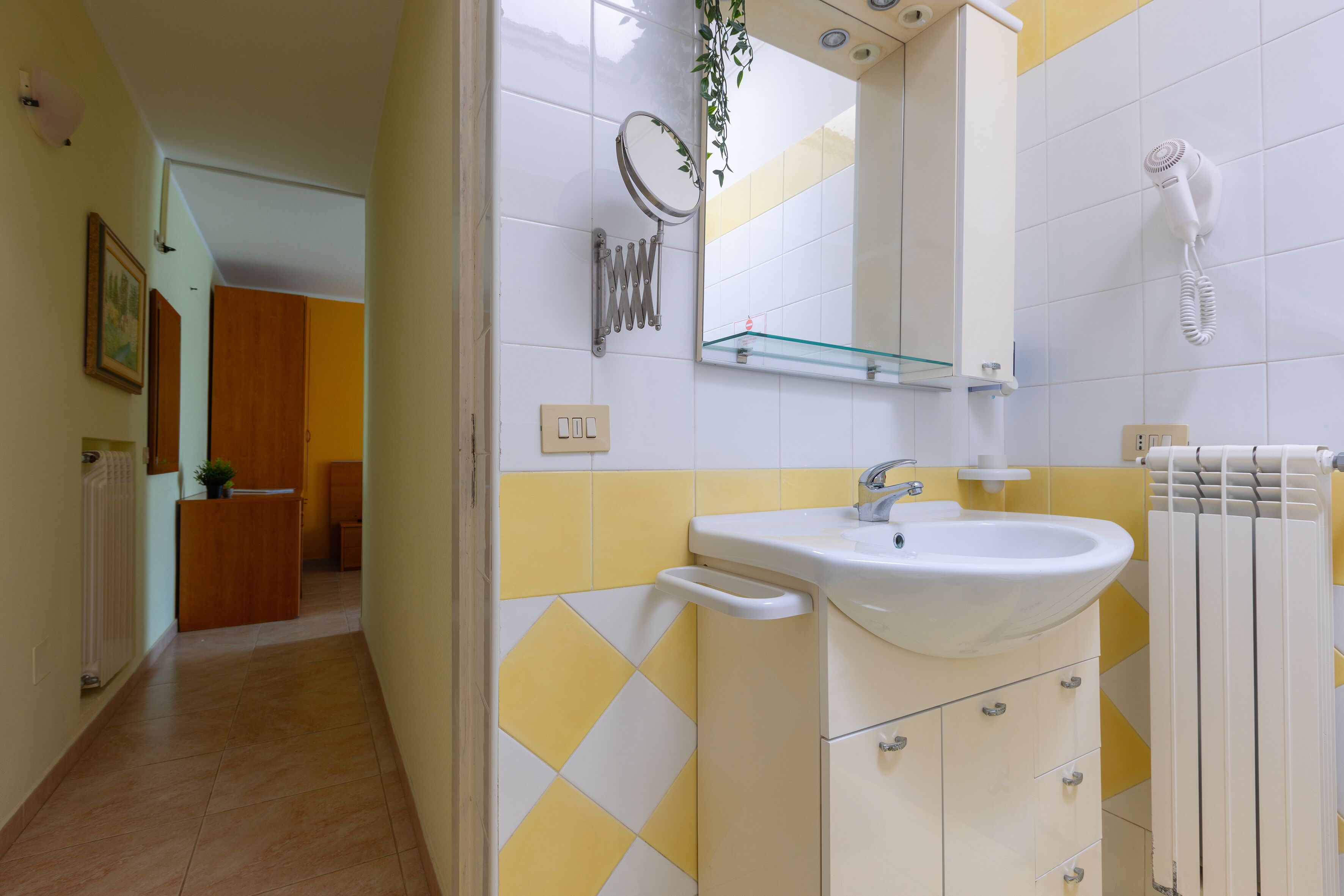 A bathroom with a sink, mirror, and towel rack.