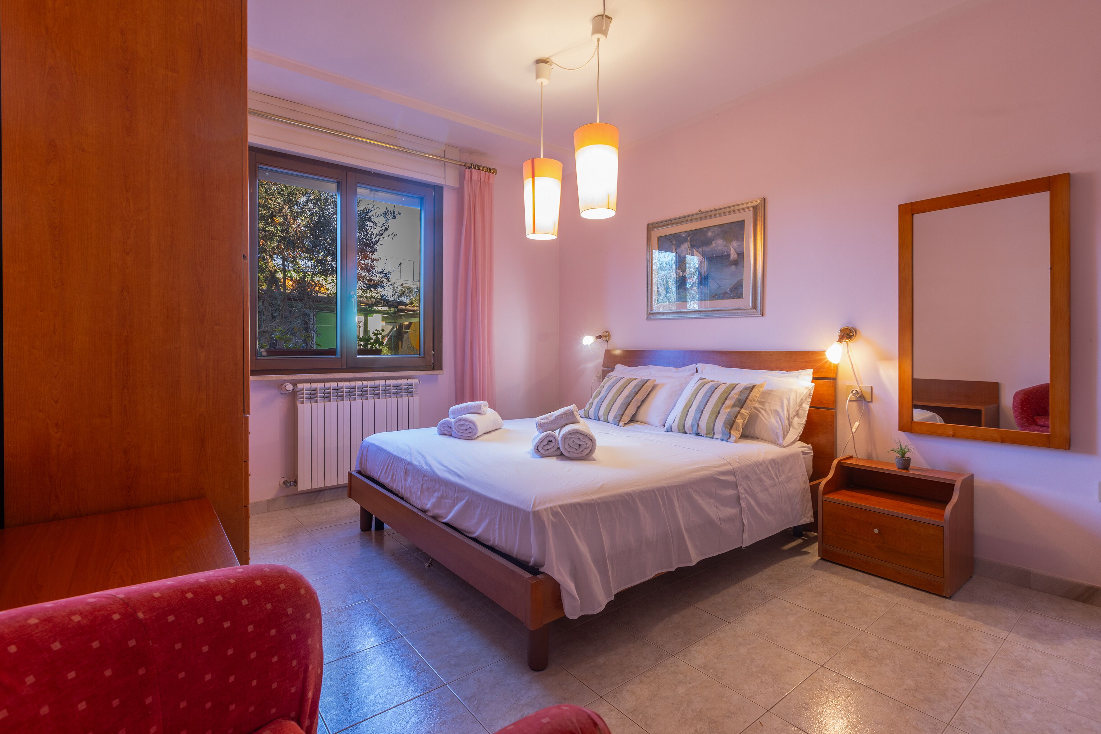 Une chambre à coucher avec un lit, une table de chevet et une fenêtre avec des rideaux.