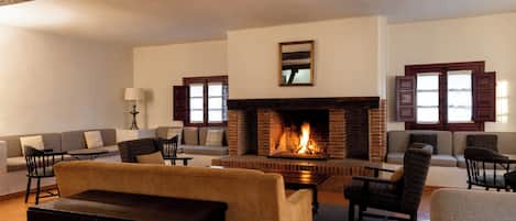 A spacious living room with a fireplace, sofas, armchairs, and a coffee table.