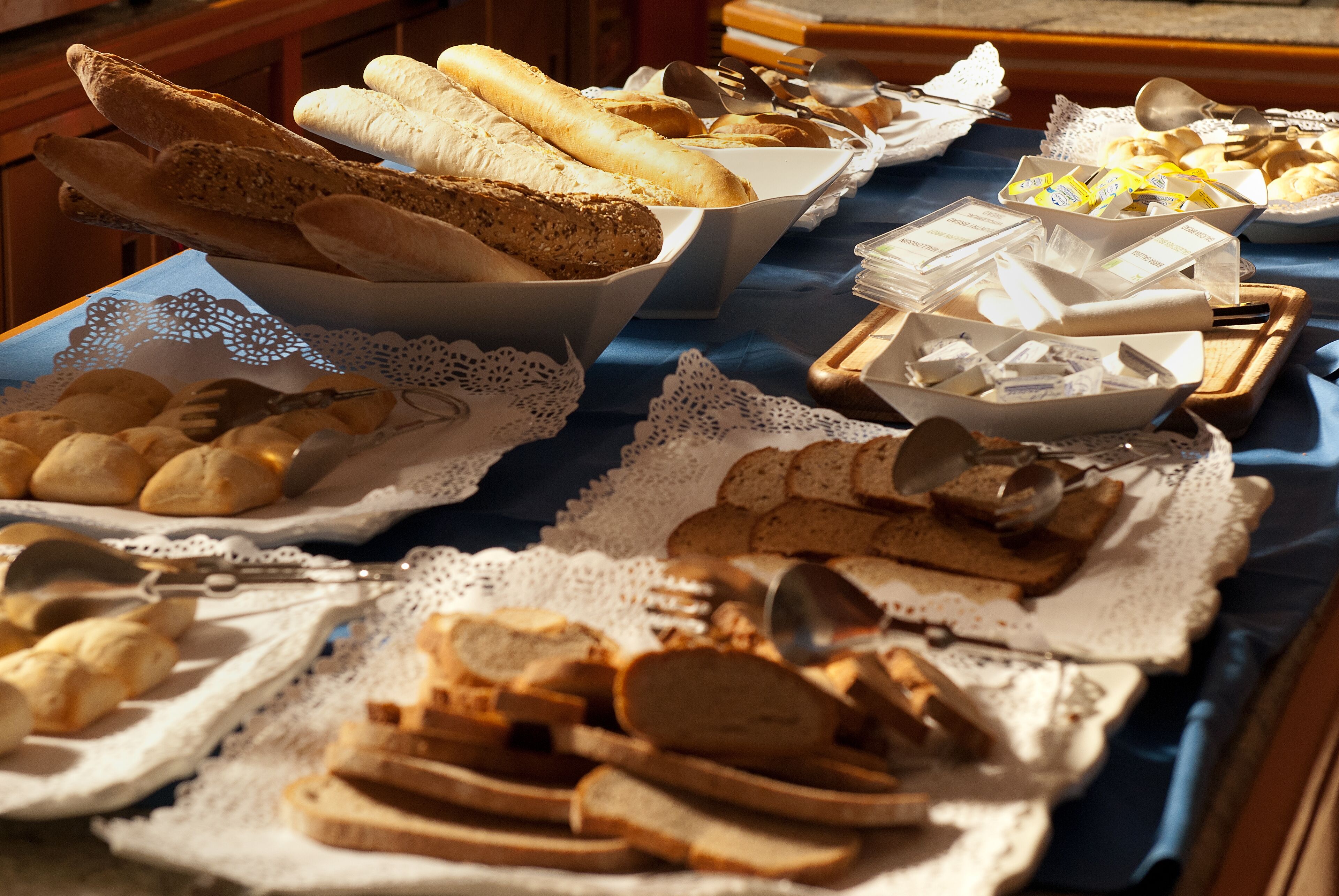 Ein reichhaltiges Buffet mit verschiedenen Brotsorten, Gebäck und Besteck.