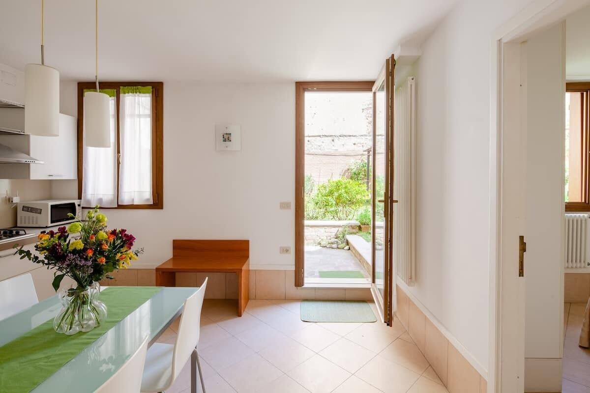 Una cocina moderna con armarios blancos, un microondas y un florero sobre la encimera.