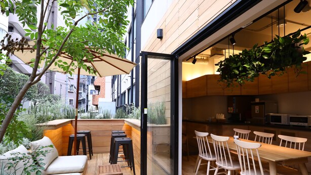 An outdoor patio area with wooden flooring, a seating arrangement, and a view of the cityscape. - KOKO HOTEL Korakuen (Tokyo)