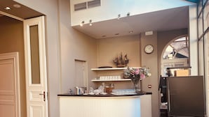 A modern kitchen with a central island, a clock on the wall, and a window providing natural light. - Ter Duinen (Bruges)
