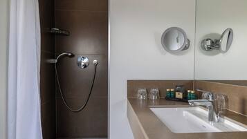 A modern bathroom with a shower, a sink, and a mirror.