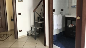 A bathroom with a white sink, a mirror, and a blue-tiled shower area. - B&B Art Suite Principe Umberto (Naples)