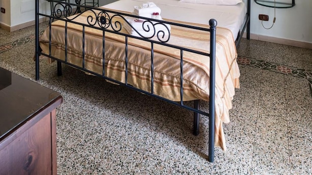 A bedroom with a bed, a chandelier, a painting, a mirror, and bedside tables. - B&B Art Suite Principe Umberto (Naples)