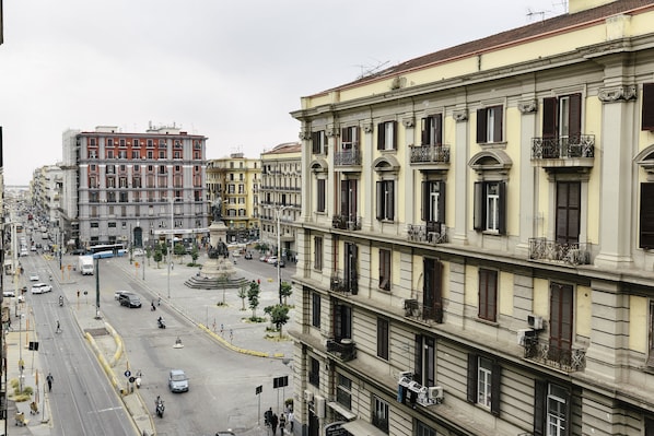 A multi-story building with balconies and a street in front.