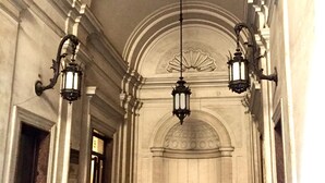 A hallway with ornate columns, a high ceiling, and three hanging lanterns. - Best Pantheon B&B (Rome)