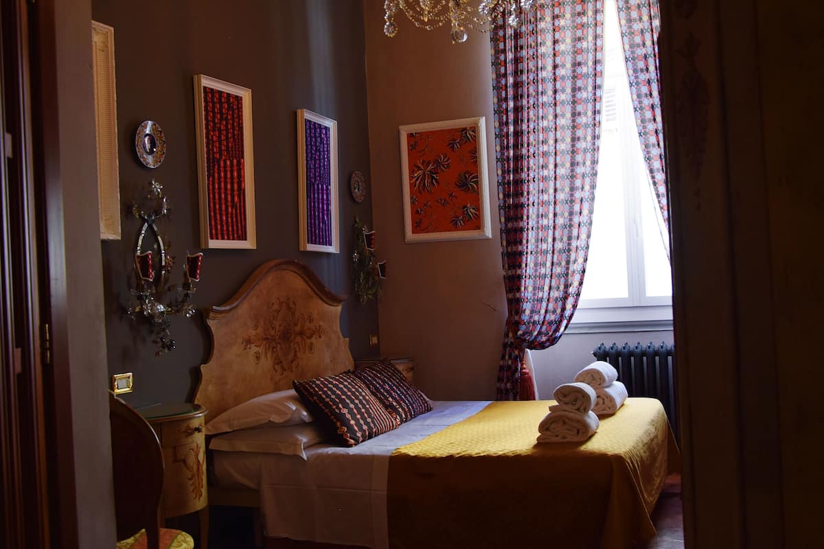 Un dormitorio con una cama grande, una araña y obras de arte en las paredes.