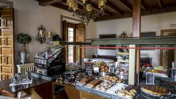 Een buffetruimte met diverse gerechten, een koffieapparaat en een kroonluchter.