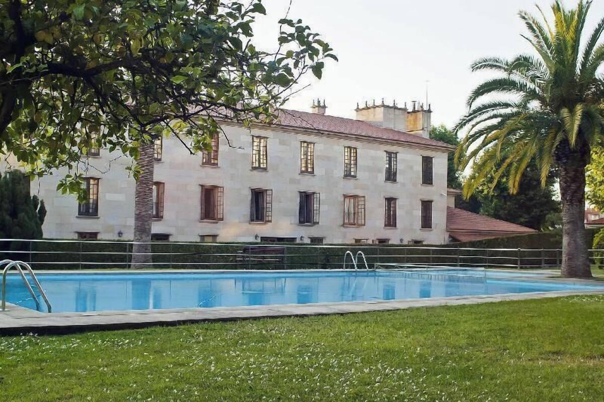 Un grand bâtiment avec une piscine devant.