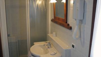 A bathroom with a shower, sink, and bidet.