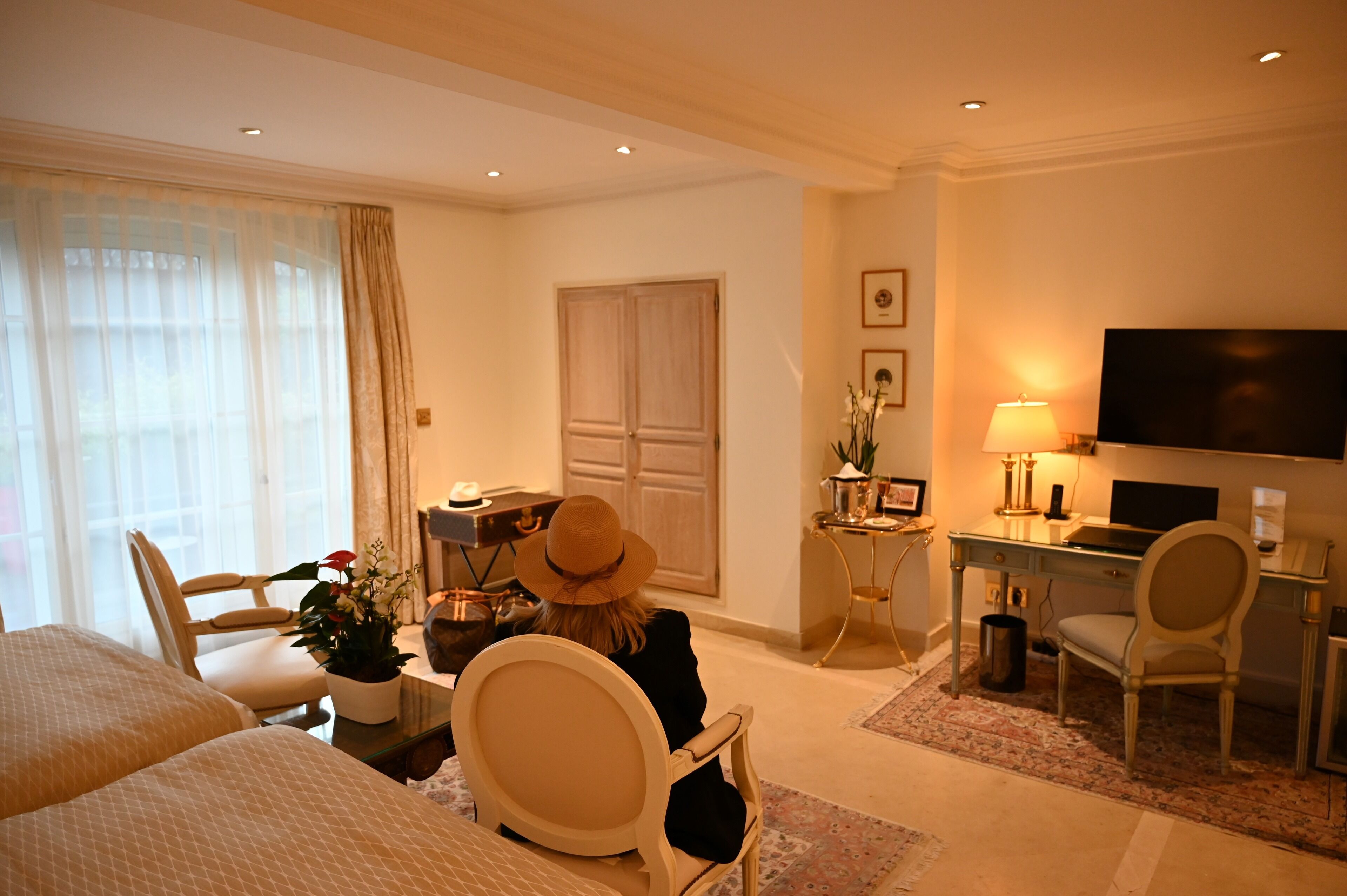 Una habitación de hotel con cama, escritorio, televisor y silla.