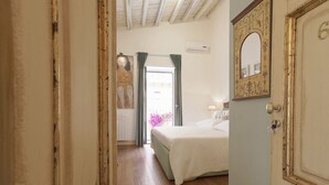 A bedroom with a bed, a door with a number, and a window with curtains. - Camere a Sud (Agrigento)