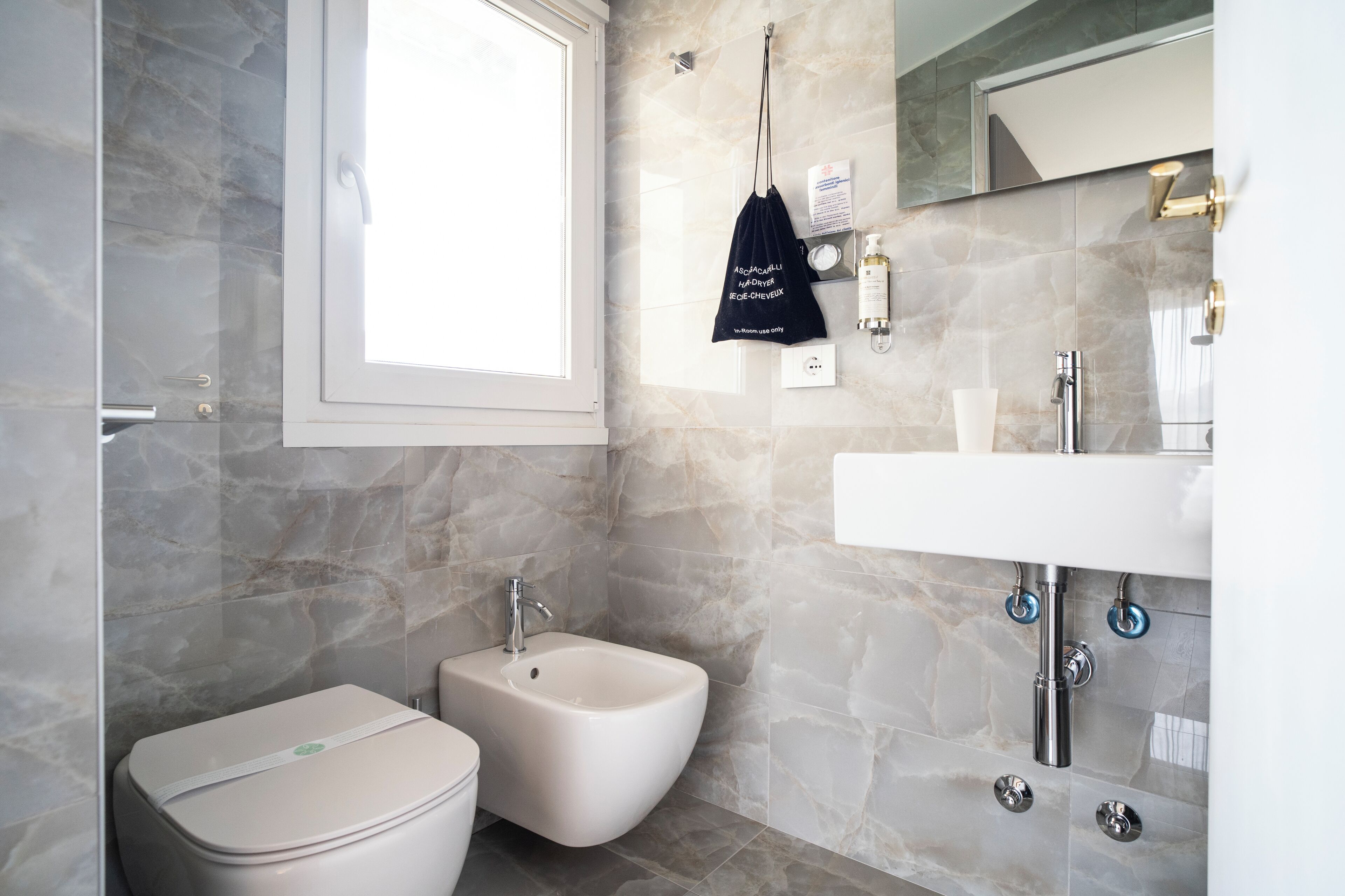 Un baño moderno con bidé, inodoro y lavamanos.