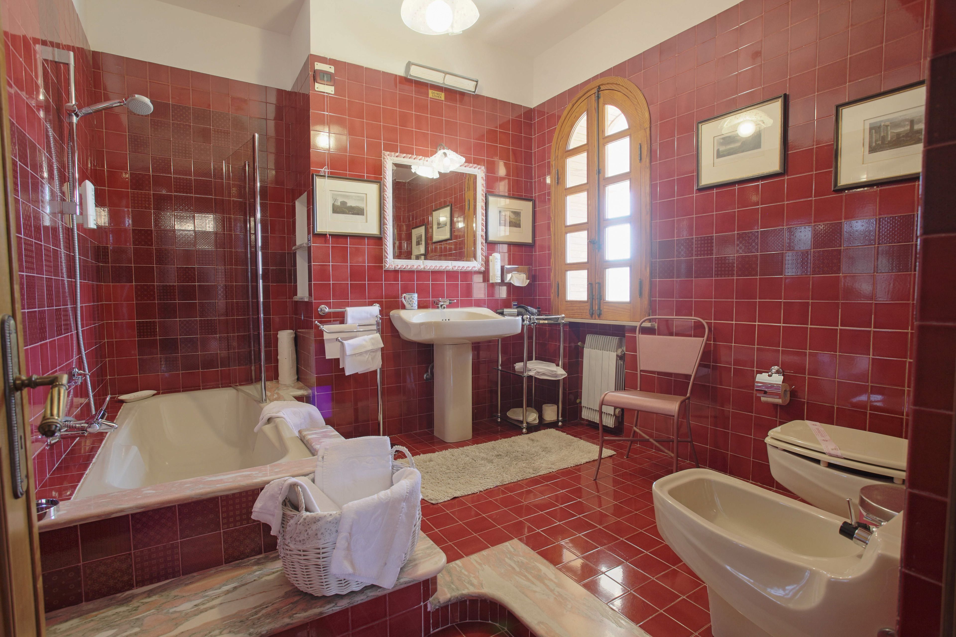 Un baño con bañera, lavamanos, inodoro y ducha.