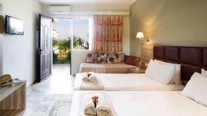 Quarto de hotel com duas camas, um sofá, uma televisão e vista para o exterior.