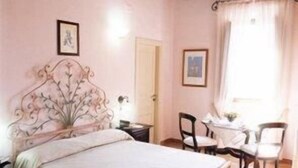 A bedroom with a large bed, a wooden ceiling, a chair, a small table, and a window with curtains. - Casale 900 (Capaccio-Paestum)