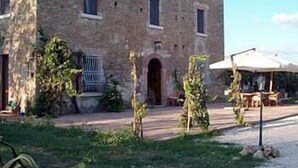 A stone building with a central entrance and windows. - Casale 900 (Capaccio-Paestum)