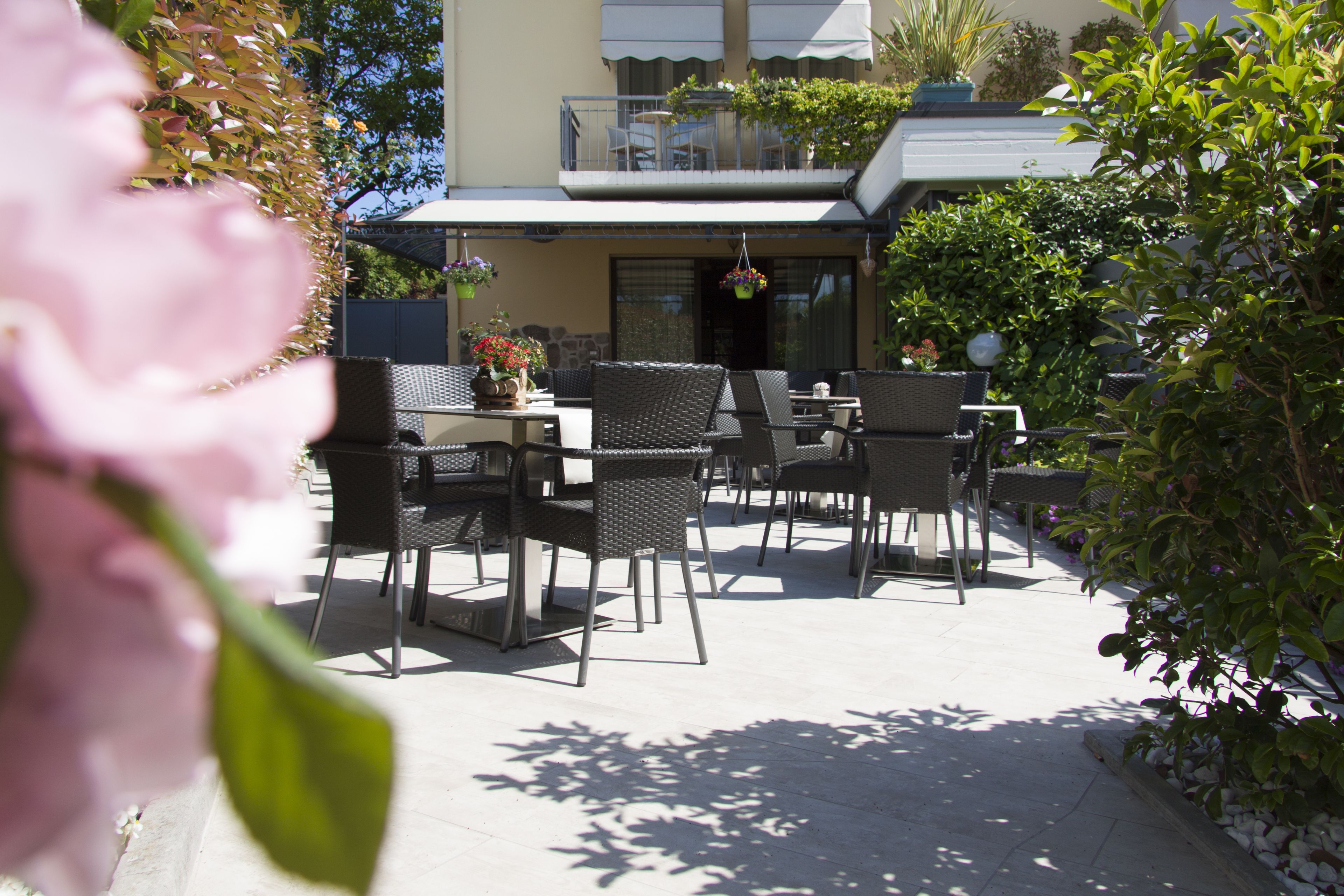 Eine Terrassengruppe mit Korbmöbeln, einem Tisch und hängenden Blumenkörben.