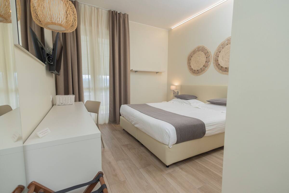 A modern bedroom with a bed, bedside table, and a desk.