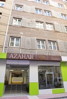 Rakennuksessa on kyltti, jossa lukee ”AZAHAR CHURRA”, ja sen modernissa sisäänkäynnissä on portaita ja lasiovet.