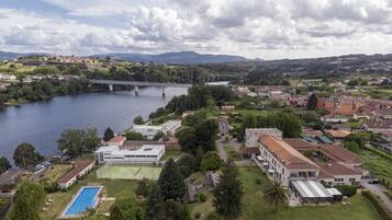 A riverside town with a bridge, buildings, and a swimming pool.