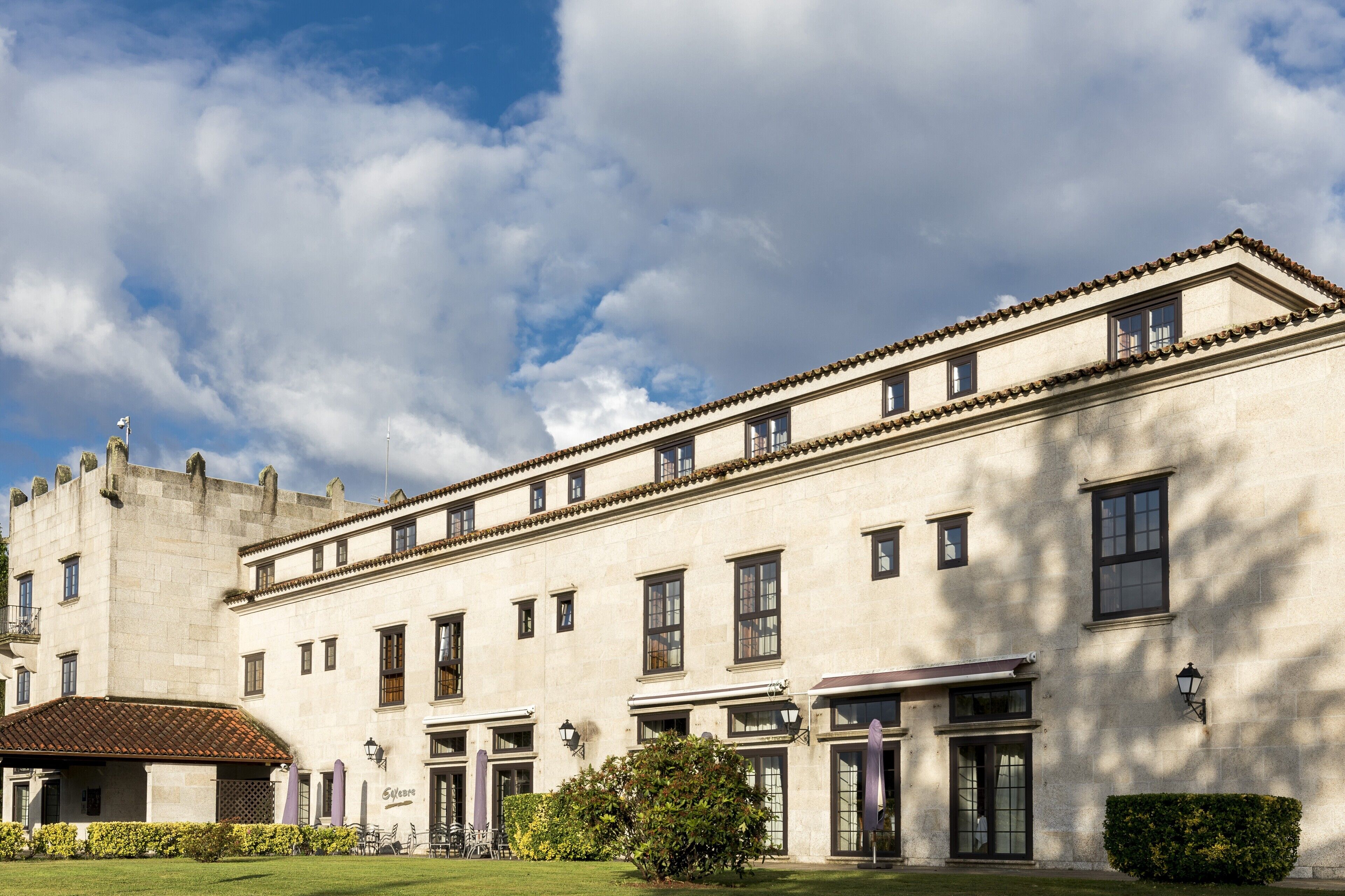 Un bâtiment historique à la façade symétrique, doté de nombreuses fenêtres et d’une entrée centrale.