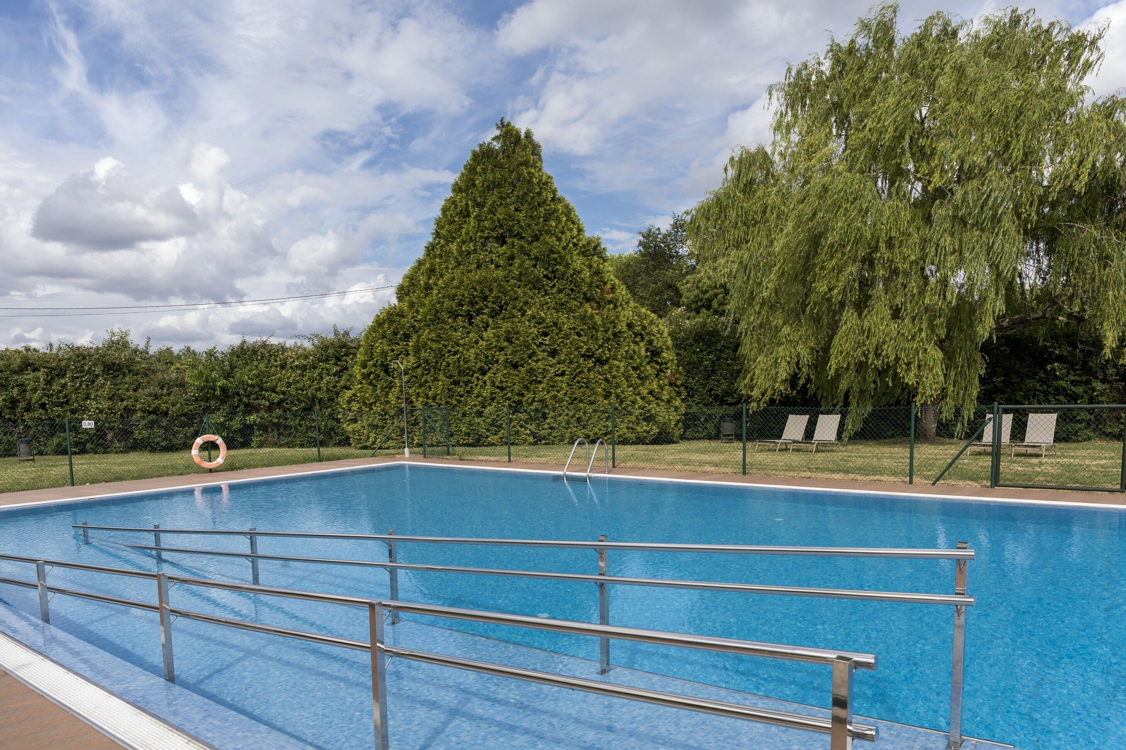 A rectangular swimming pool with metal railings and a lifebuoy.