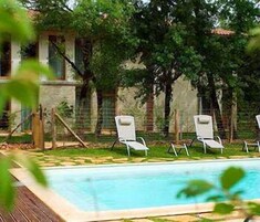 Una piscina al aire libre, sillones reclinables de piscina