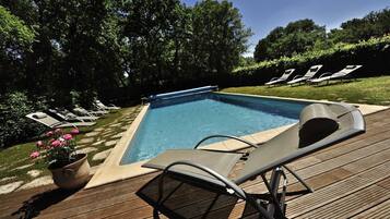 Alberca al aire libre y camastros