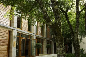 Stunning building with large windows and doors, offering a glimpse into the interior amidst lush green surroundings.