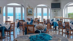 A dining area with round tables, chairs, and a view of the sea. - Calabattaglia (Ventotene)