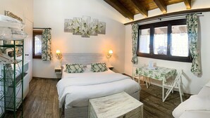 A cozy room with a bed, a small table, and a chair. There is a window with curtains, a wall-mounted lamp, and a wooden ceiling. - Villa ai Tigli Venice Airport Rooms Online Check-in & Keypad Access (Mestre)