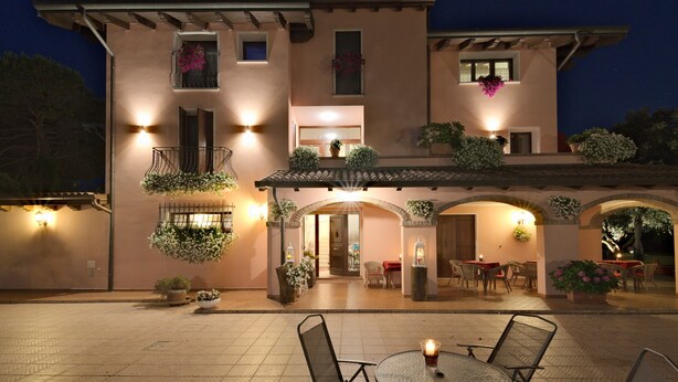 A building with a patio area featuring outdoor seating and potted plants. - Villa ai Tigli Venice Airport Rooms Online Check-in & Keypad Access (Mestre)