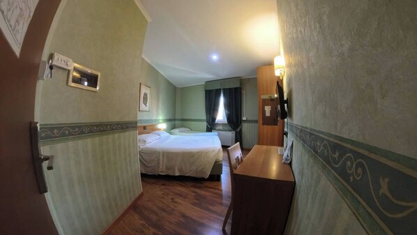Una habitación de hotel con cama, escritorio y silla.