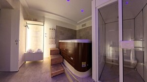 Un baño moderno con cabina de ducha de vidrio, un banco de madera y una sauna.