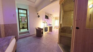 Un pasillo con una puerta de madera, una silla y un mostrador con objetos encima.